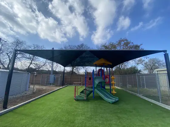 Artificial turf playground area under a shade structure