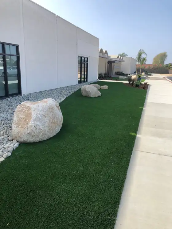 Artificial turf strip alongside a modern home and walkway